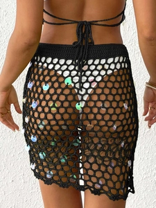 Close-up of black crochet beach skirt featuring sequins and intricate mesh texture