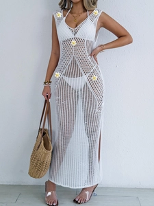 Detail of white crochet beach dress featuring knitted daisy flowers and open mesh texture