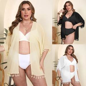Detail showing tassel trim on three colorful semi-transparent chiffon beach cover-ups