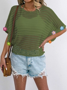 Detail of olive green knit cover-up with colorful 3D handmade crochet flower patches