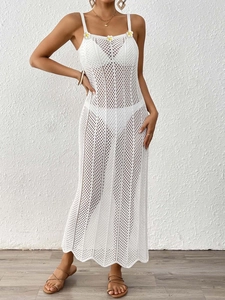 Dettaglio dell'abito da spiaggia all'uncinetto bianco con maglia e fiori di margherita gialla