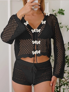 Détail du cardigan noir en maille ajourée avec appliques papillon 3D blanches