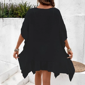 Detail of black beach cover-up featuring ruffled edges and asymmetric hemline back view