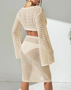 Detail of crochet knit beach set featuring openwork mesh texture and long flared sleeves
