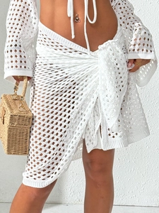 Boho white crochet two-piece beach set featuring long sleeve crop top and wrap skirt