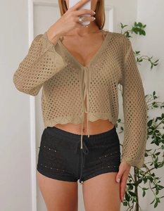 Dettaglio ravvicinato del cardigan kaki all'uncinetto con maniche lunghe e chiusura frontale