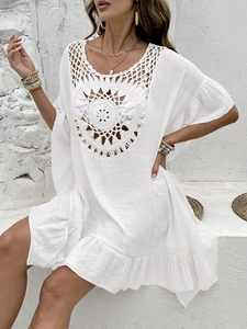 Detailed close-up of intricate circular crochet pattern on a white boho beach cover-up