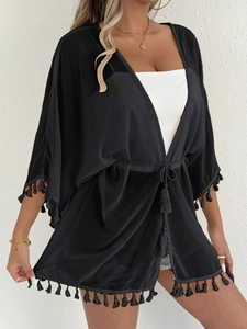 Detail of black chiffon kimono cover-up featuring fringe tassels and waist tie closure