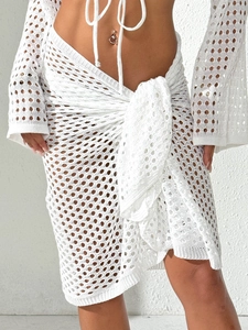 Detailed view of white crochet lace beach skirt set with intricate hollow-out knit patterns