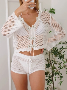 Détail d'un cardigan blanc en maille crochetée avec papillons 3D et motif de dentelle ajouré