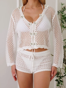 Détail du haut en crochet blanc avec appliques papillon 3D et lacets sur le devant