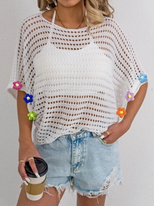 Close-up of white crochet hollow cover-up featuring colorful 3D floral sleeve details