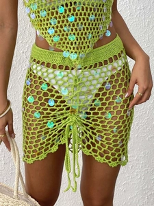 Detail of green crochet skirt with colorful sequins and adjustable drawstring design