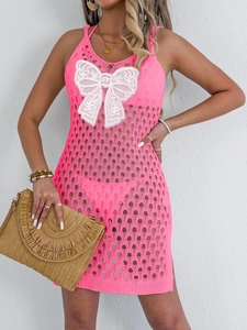 Close-up of hollow crochet knit texture and white lace butterfly on neon pink dress