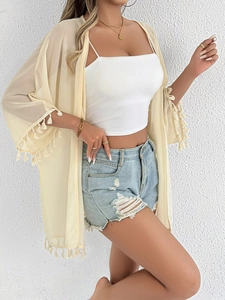 Detail of bohemian chiffon cover-up featuring fringe tassels on sleeves and hem