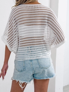 Close-up of the hollow crochet knit texture and fringe denim shorts on female model