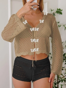 Détail d'un cardigan en dentelle au crochet kaki avec papillons 3D et liens à nouer