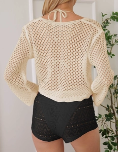 Gros plan sur la maille crochetée et les détails en résille au dos du cache-maillot ivoire