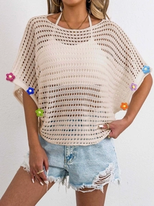 Close-up of beige crochet knit top with colorful 3D floral accents and batwing sleeves