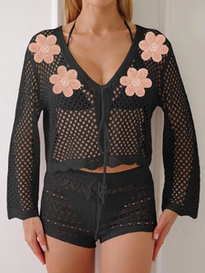 Dettaglio completo di set due pezzi nero all'uncinetto con fiori rosa e trama traforata