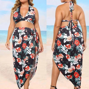 Front and back view of plus size floral halter top and wrap skirt bikini set on beach