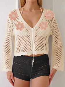Cardigan bohémien in maglia color crema con ricami floreali rosa e chiusura con laccetti