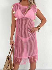 Détail de la robe de plage crochet rose avec appliques de fleurs blanches et franges