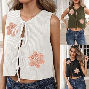 Détails du gilet en tricot avec nœuds de serrage avant et appliques de fleurs au crochet