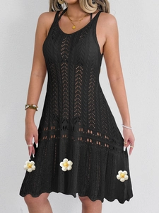 Close-up of black crochet knit dress with geometric cutout patterns and halter neckline