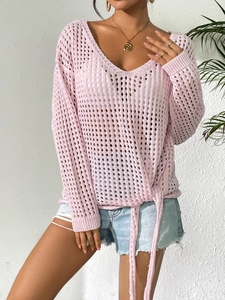 Detail of light pink hollow knit cover-up showing side drawstring ties and floral texture