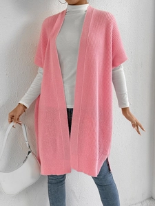 Detail of pink knit vest cardigan featuring chunky texture and stylish side slits