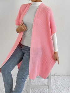 Pink knit cardigan vest with textured pattern over white turtleneck and jeans
