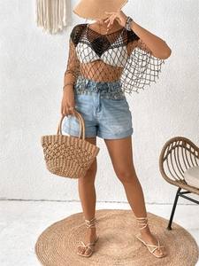 Detail of black crochet mesh cover-up featuring intricate beadwork and fringe hem style