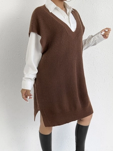 Dettaglio gilet lungo in maglia con scollo a V e spacco laterale su camicia bianca
