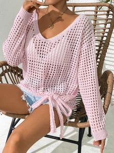Detail of pink hollow-out knit sweater featuring delicate mesh texture and hem tie-up bow