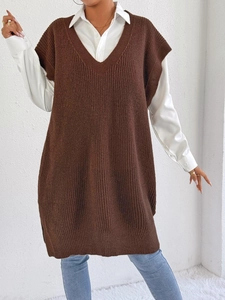 Dettaglio di un abito a gilet in maglia marrone oversize con scollo a V e trama a costine