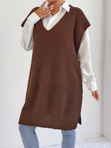 Dettaglio del gilet in maglia marrone scuro con scollo a V e spacchi laterali