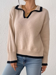 Detail shot of beige knit polo sweater with black contrast trim on collar and cuffs