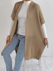 Close-up of camel knit texture and open-front hem on a long sleeveless cardigan