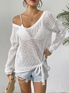Detailed macro shot of white hollow-out knit cover-up featuring elegant side bow tie-up