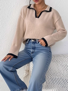 Close-up of knit polo sweater featuring contrast black trim on the collar and cuffs