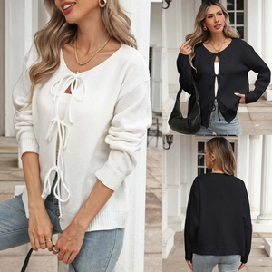 Detail of knit cardigan showing triple tie-front bow closures and soft textured fabric