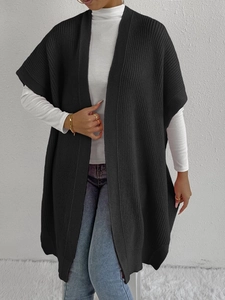 Close-up of a black oversized chunky knit cardigan vest with a thick woven texture