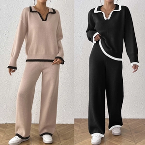 Détail du pull en maille à col en V et du pantalon large avec bordure contrastée