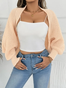 Detail der hellen pfirsichfarbenen Strickjacke mit Häkelstich und weiten Laternenärmeln