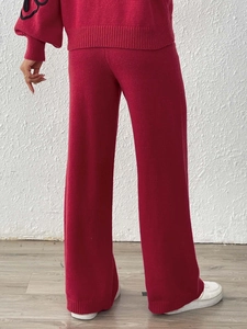 Detail of red knitted wide-leg pants with ribbed hem and high waist straight cut design