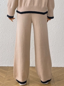 Completo in maglia color avena con bordi neri a contrasto e pantaloni larghi vista retro