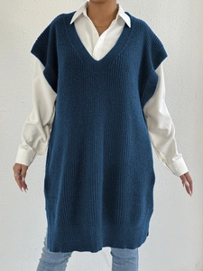 Dettaglio del gilet in maglia con scollo a V, spacchi laterali e texture a righe verticali
