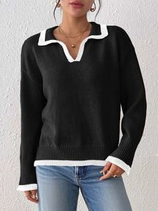 Detail of the V-neck polo collar and contrast white piping on a black knit sweater