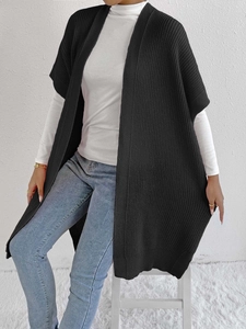 Detail of black oversized knit cardigan texture and casual layering on female model